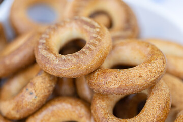Freshly baked mini bagels on a dark background. Top view. Pretzels in the form of a ring close-up. Small bread circle biscuit. Bowls with different types of bagels.