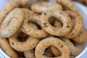 Freshly baked mini bagels on a dark background. Top view. Pretzels in the form of a ring close-up. Small bread circle biscuit. Bowls with different types of bagels.