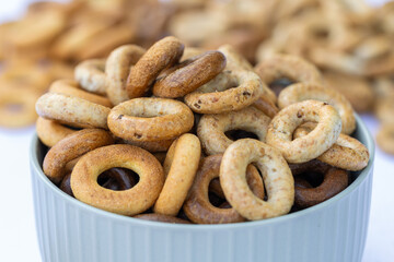 Freshly baked mini bagels on a dark background. Top view. Pretzels in the form of a ring close-up. Small bread circle biscuit. Bowls with different types of bagels.