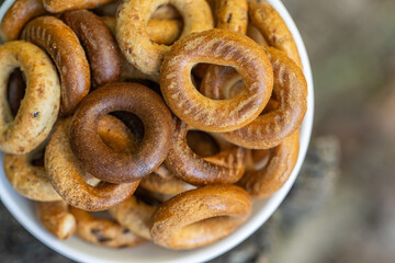 Freshly baked mini bagels on a dark background. Top view. Pretzels in the form of a ring close-up. Small bread circle biscuit. Bowls with different types of bagels.