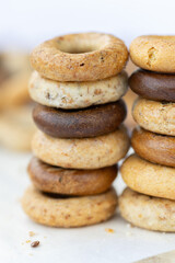 Freshly baked mini bagels on a dark background. Top view. Pretzels in the form of a ring close-up. Small bread circle biscuit. Bowls with different types of bagels.