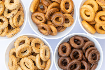 Freshly baked mini bagels on a dark background. Top view. Pretzels in the form of a ring close-up. Small bread circle biscuit. Bowls with different types of bagels.