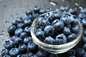 Delicious fresh blueberries in a bowl on a gray table, close-up
