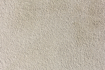 A view of a pebble dash style stucco wall texture, as a background.