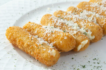 A view of a plate of mozzarella sticks.