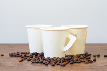 Coffee paper cup on wooden table. Mockup for you designs.