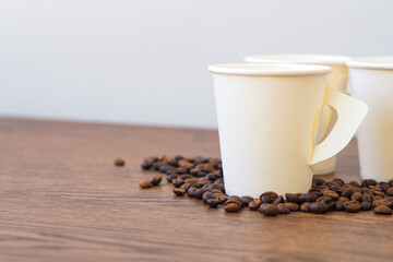 Coffee paper cup on wooden table. Mockup for you designs.