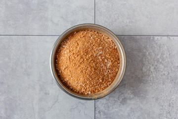 A top down view of a condiment cup of powdered shrimp.