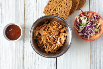 A top down view of a metal bowl of jackfruit pulled pork.