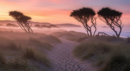 Naklejka premium Mystical Beach Landscape with Foggy Horizon and Silhouette Trees at Sunset a Dreamy Coastal Scenery
