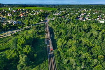 Aerial drone view of passenger locomotive with wagons in moving on railroad. Traveling on Passenger train on railway.