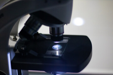 Close-up of a microscope with illuminated slide
