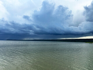 Scenic View of a Calm Lake Under Dramatic Cloudy Skies with Reflections and Natural Landscape