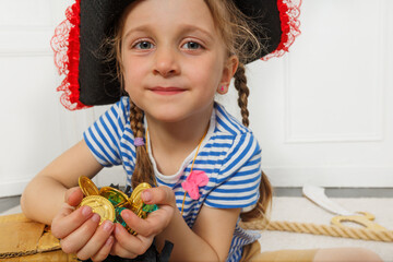 Kid girl in striped shirts enjoying a pirate-themed coin game