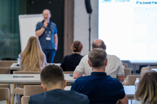 Business or educational seminar with presenter speaking to audience in classroom setting - Powered by Adobe