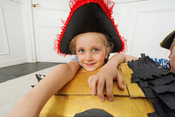 Close-up of pirate girl hugging treasure chest in playful moment