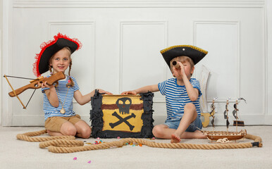 Young pirates with a treasure chest and telescope in playtime