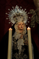close-up of a statue of the Virgin Mary crying, wearing a silver crown and an ornate cloak, located...