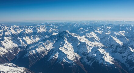 Snowy mountain range peaks under bright clear sky with crisp winter air