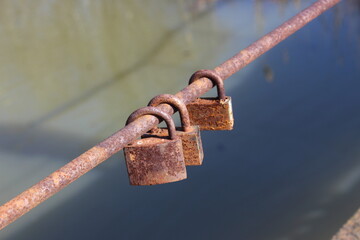 Old rusty love locks on bridge