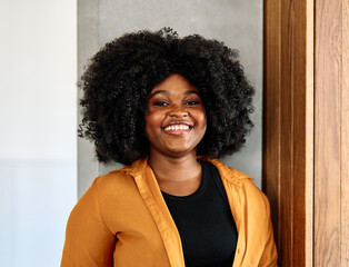 Portrait of a young happy black woman posing at home or in the office