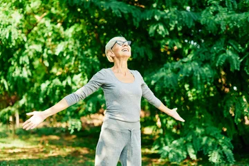 Selbstklebende Fototapeten Entspannung Happy active senior woman meditating and daydreaming and relaxing and nature outdoors  © Lumos sp