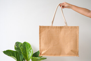 Woman holding  jute bag or sack bag on white background. Reusable shopping bag. Natural material. Zero waste. Plastic free. Eco friendly concept.
