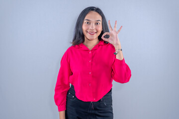 Indonesian Asian woman wearing red dress smiling and giving ok sign