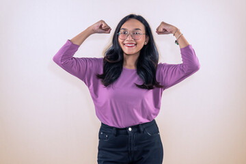Indonesian Asian woman wearing purple clothes smiling and raising both hands