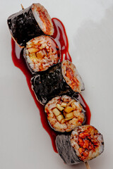 Sushi maki in bright sauce. High contrast
