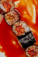 Sushi maki in bright sauce. High contrast