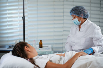 Nurse Preparing and Administering an IV Drip to a Young Patient
