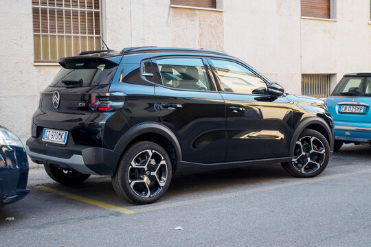 Black Citroen C3 Aircross and blue Mini Cooper parked side by side, highlighting compact urban vehicle styling against city street background