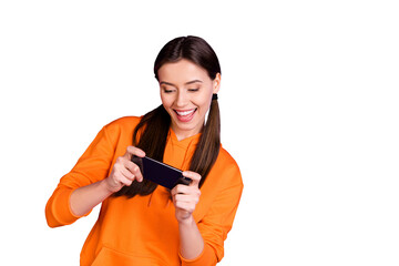 Portrait of addicted crazy funny funky teenager girl use her smartphone play game wear orange...