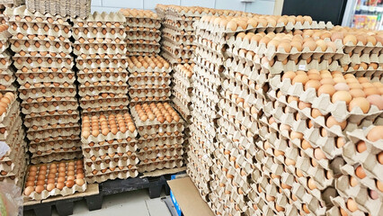 Fresh Eggs Displayed: A large collection of fresh eggs neatly stacked in cardboard cartons,...