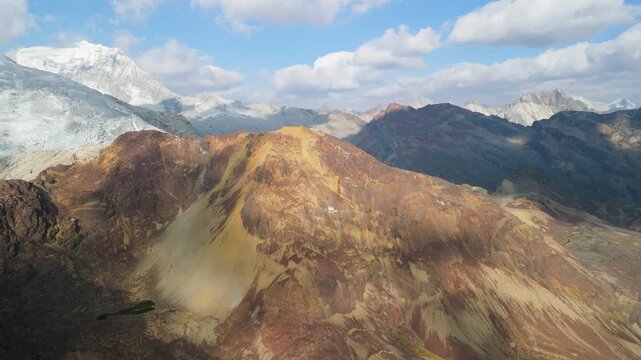 High altitude aerial pan left across the rugged Paso del Zorro in Peru&rsquo;s Cordillera Blanca, revealing colorful peaks, glacial snow, and dramatic Andean scenery.