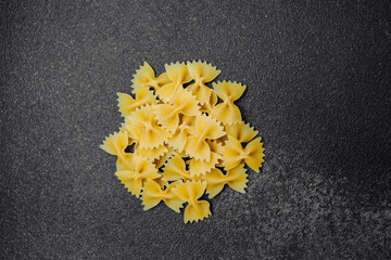 Farfalle pasta arranged on dark surface with natural light during the day