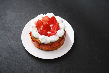 Strawberry shortcake with whipped cream topping on white plate dessert concept for birthday...