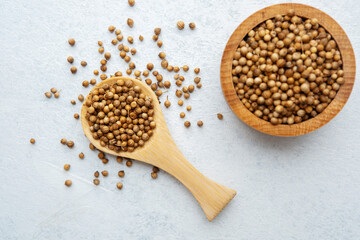 wooden bowl and spoon with coriander seeds on white background