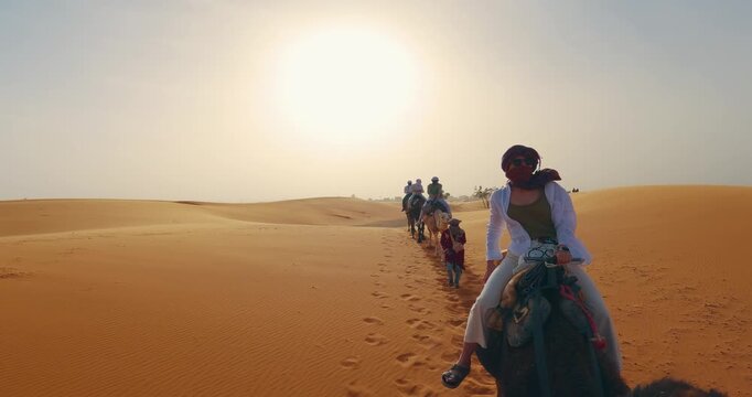 Group camel ride exploring desert dunes under the vibrantly glowing sun