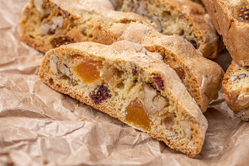 Italian Almond Biscotti biscuits in a rustic home made pottery bowl. Studded with almonds and cranberries, these twice-baked treats are aromatic and inviting. Ideal.