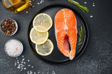 Fresh salmon fillet with lemon slices and herbs ready for cooking