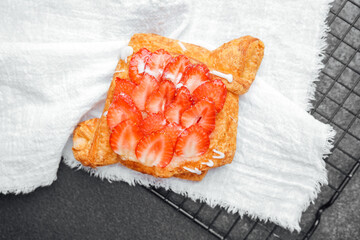 Delicious pastry topped with fresh strawberries on a cooling rack