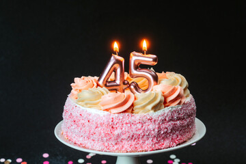 Celebrating a significant birthday with a pink frosted cake and candles