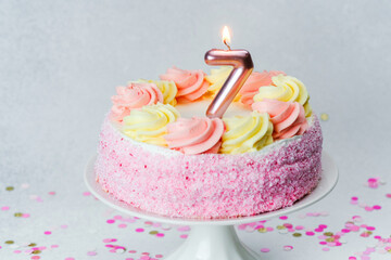 Birthday cake with pink and yellow frosting celebrating seventh birthday