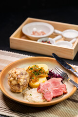 Bavarian dumplings with roasted pork, sauerkraut and potato dumpling lying on a plate
