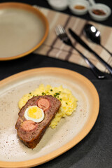 Typical Czech cuisine minced roast pork and beef with egg, sausage and mashed potatoes