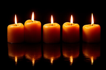 Five orange candles with flickering flames are lit against a black background, casting warm reflections on a glossy surface below