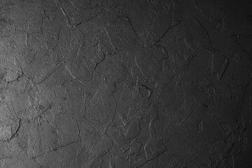 Black textured background surface with cracked pattern