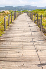 A wooden boardwalk leading a path to the beach and ocean journey concept